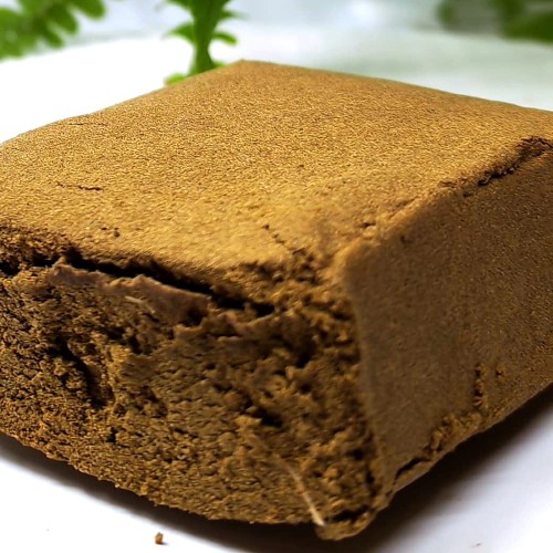 Bloc de résine CBD Honey Hash Lemon photographié sur fond clair